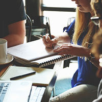 Woman with a notebook and pen - attracting and keeping clients